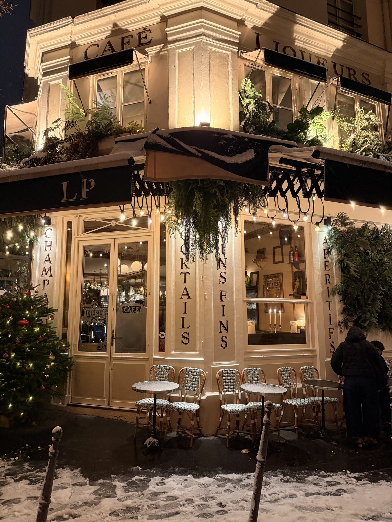 A neighbourhood café lit up on a snowy winter night